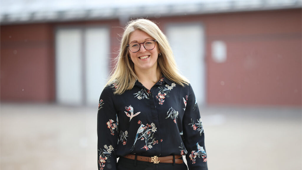 bild på person utomhus. personen ler och ser glad ut. bilden utstrålar värme