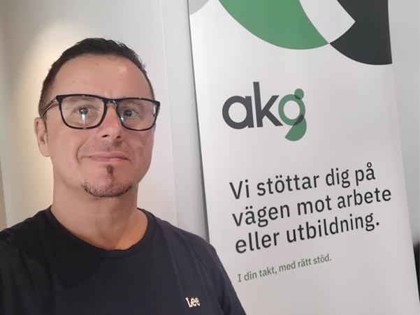 Medarbetare framför AKG skylt.